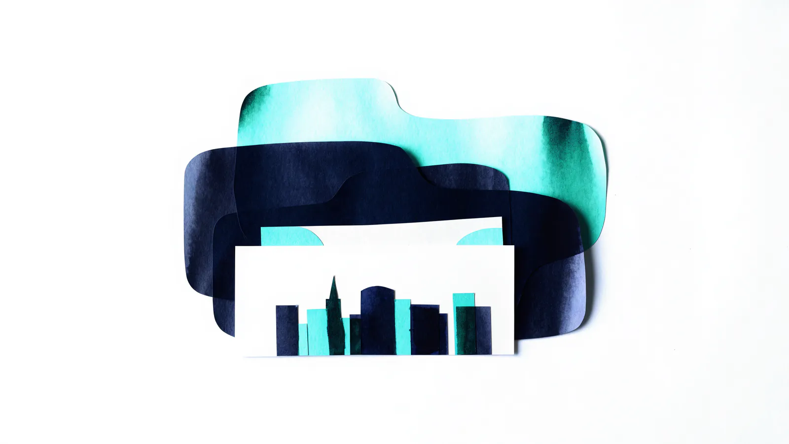 Row of small paper-cut buildings standing on a ledger sheet, representing rental property financing