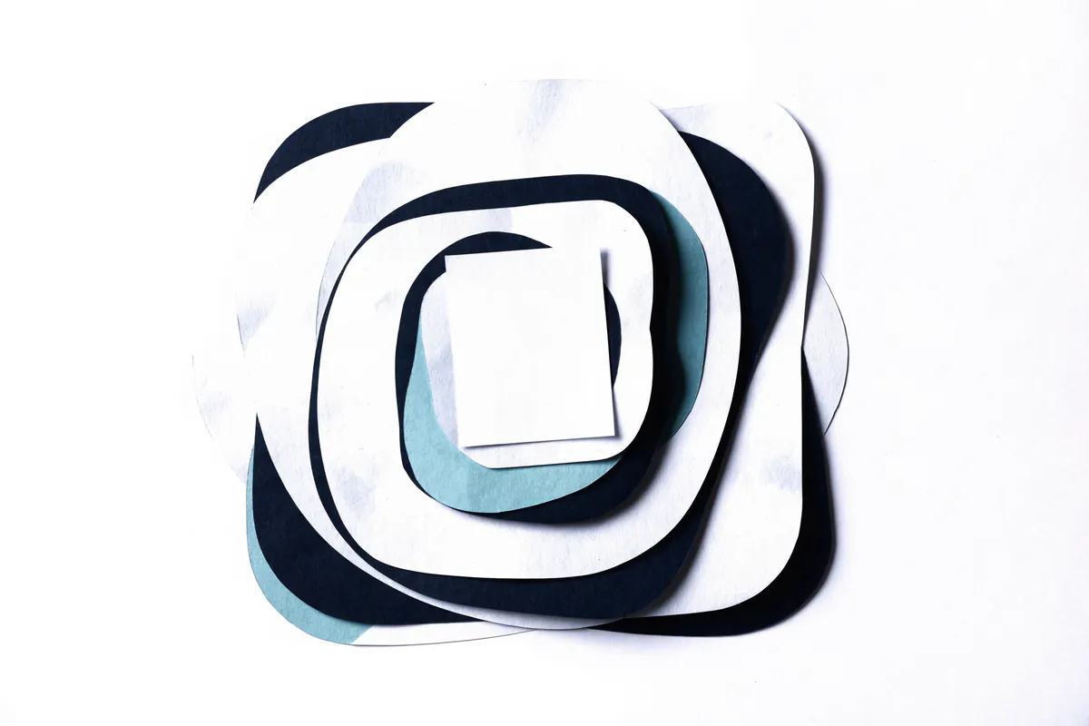 A small paper card nested inside larger cut paper frames, representing a calculator embedded in another page